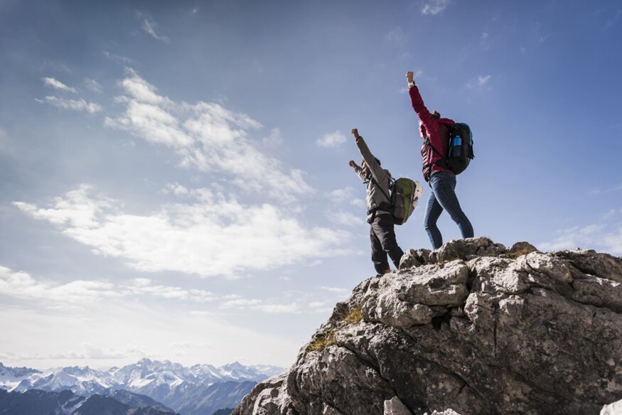 Two people celebrating on a mountain summit